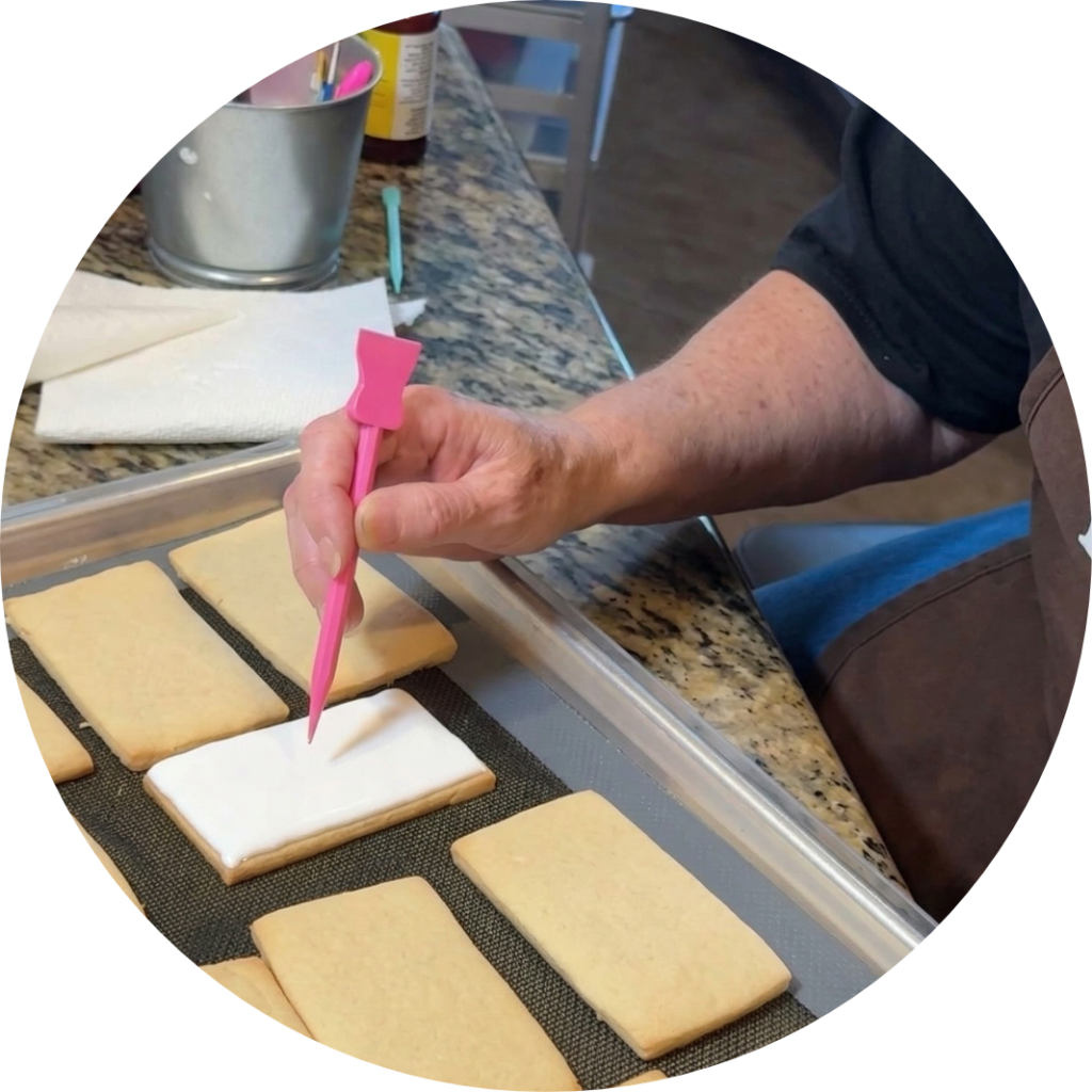 Carrie Perry decorating custom cookies with frosting